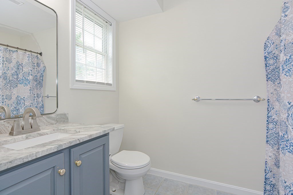 28 Aroostook Street Worcester, MA 01606 - Photo 15 of 40 a bathroom with a granite countertop sink toilet and a mirror