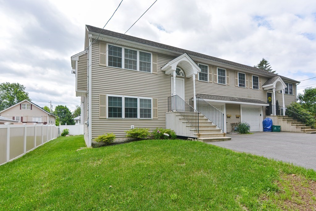 28 Aroostook Street Worcester, MA 01606 - Photo 2 of 40 a front view of a house with a yard and garage