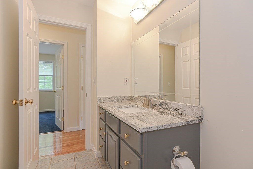 28 Aroostook Street Worcester, MA 01606 - Photo 23 of 40 a bathroom with a granite countertop sink and a mirror