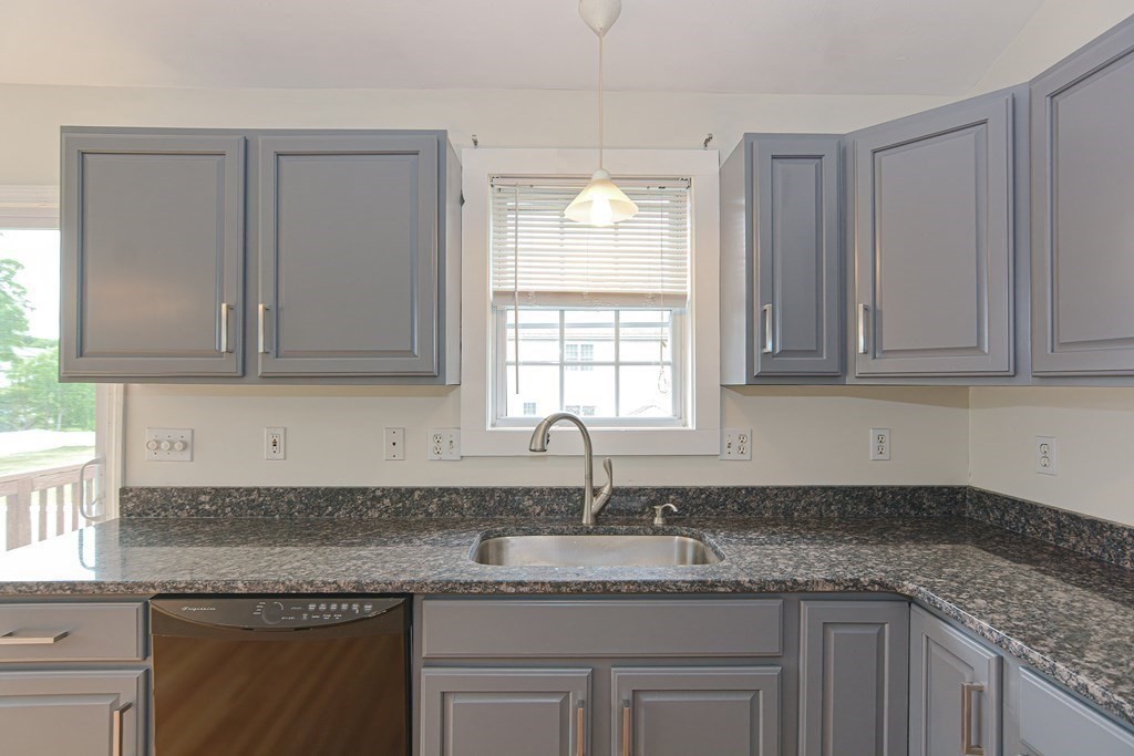 28 Aroostook Street Worcester, MA 01606 - Photo 4 of 40 a kitchen with granite countertop stainless steel appliances white cabinets sink and window