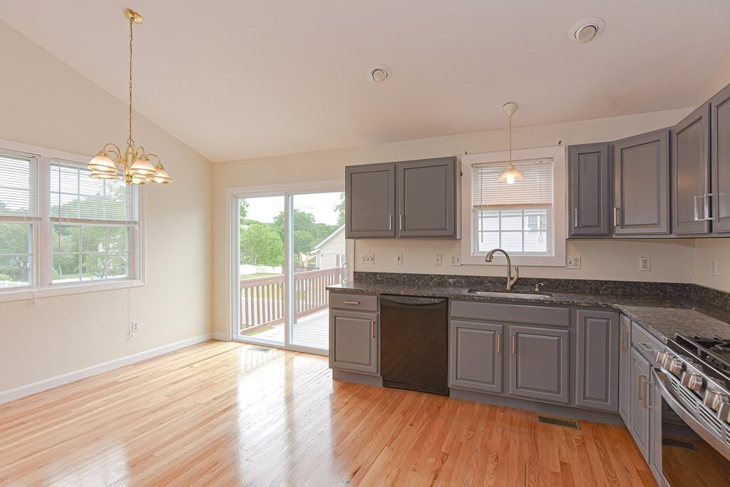 28 Aroostook Street Worcester, MA 01606 - Photo 7 of 40 a kitchen with stainless steel appliances granite countertop wooden floors a stove a sink and a window