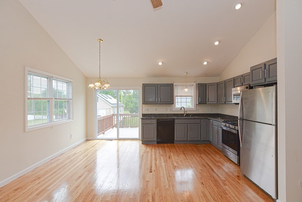 28 Aroostook Street Worcester, MA 01606 - Photo 8 of 40 a kitchen with stainless steel appliances granite countertop a refrigerator a sink dishwasher a stove and white countertops with wooden floor