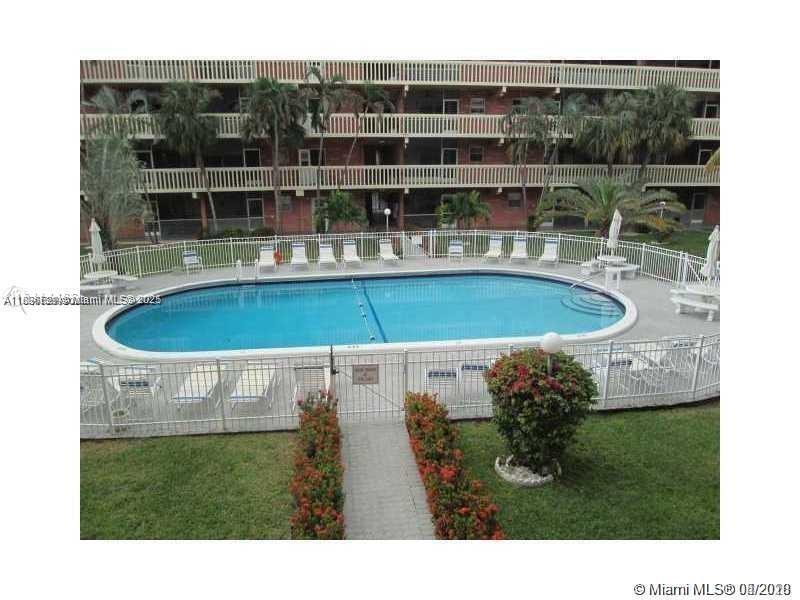 180 Northeast 12th Avenue, Unit 11E Hallandale Beach, FL 33009 - Photo 1 of 22 a view of a swimming pool with a yard