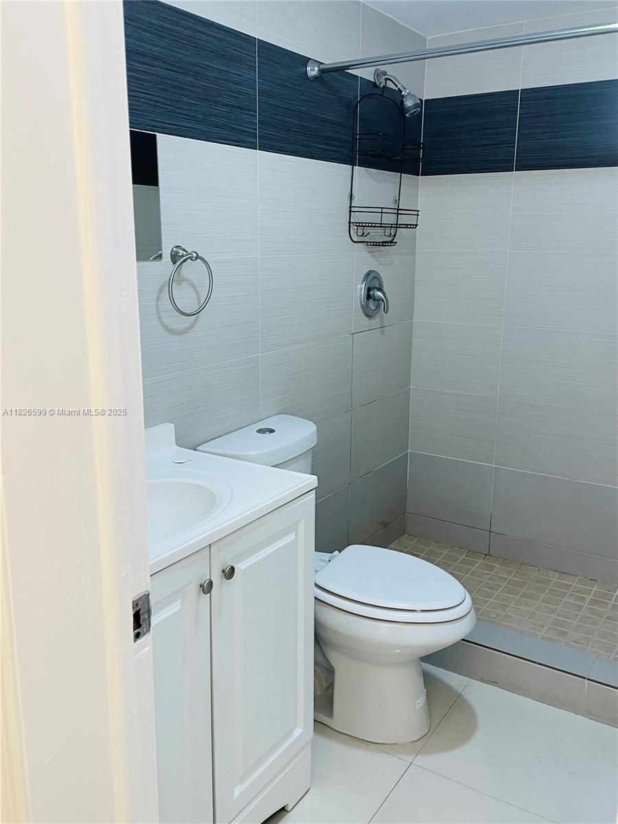 180 Northeast 12th Avenue, Unit 11E Hallandale Beach, FL 33009 - Photo 12 of 22 a bathroom with a toilet a sink and shower