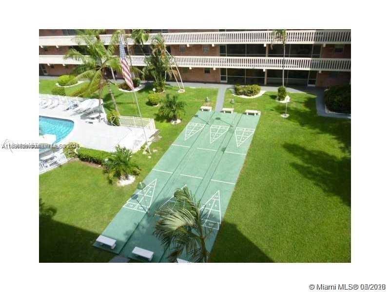 180 Northeast 12th Avenue, Unit 11E Hallandale Beach, FL 33009 - Photo 19 of 22 a view of a swimming pool with a yard