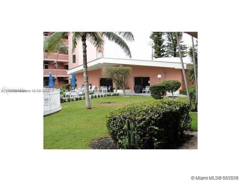 180 Northeast 12th Avenue, Unit 11E Hallandale Beach, FL 33009 - Photo 21 of 22 a view of a white house with a big yard and potted plants