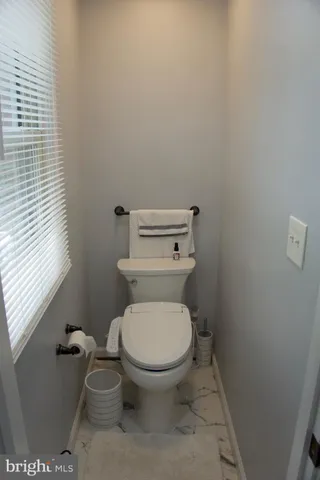 a white toilet sitting next to a window
