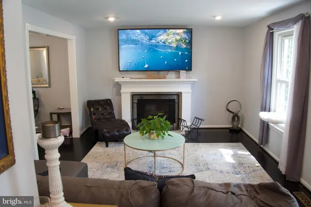 a living room with furniture a fireplace and a window