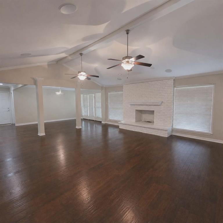 14752 Ranch Road Forney, TX 75126 - Photo 7 of 40 Spacious living area featuring rich wood-finish flooring, a white-painted brick fireplace with mantel, and multiple windows with blinds-This photo was taken before family moved in