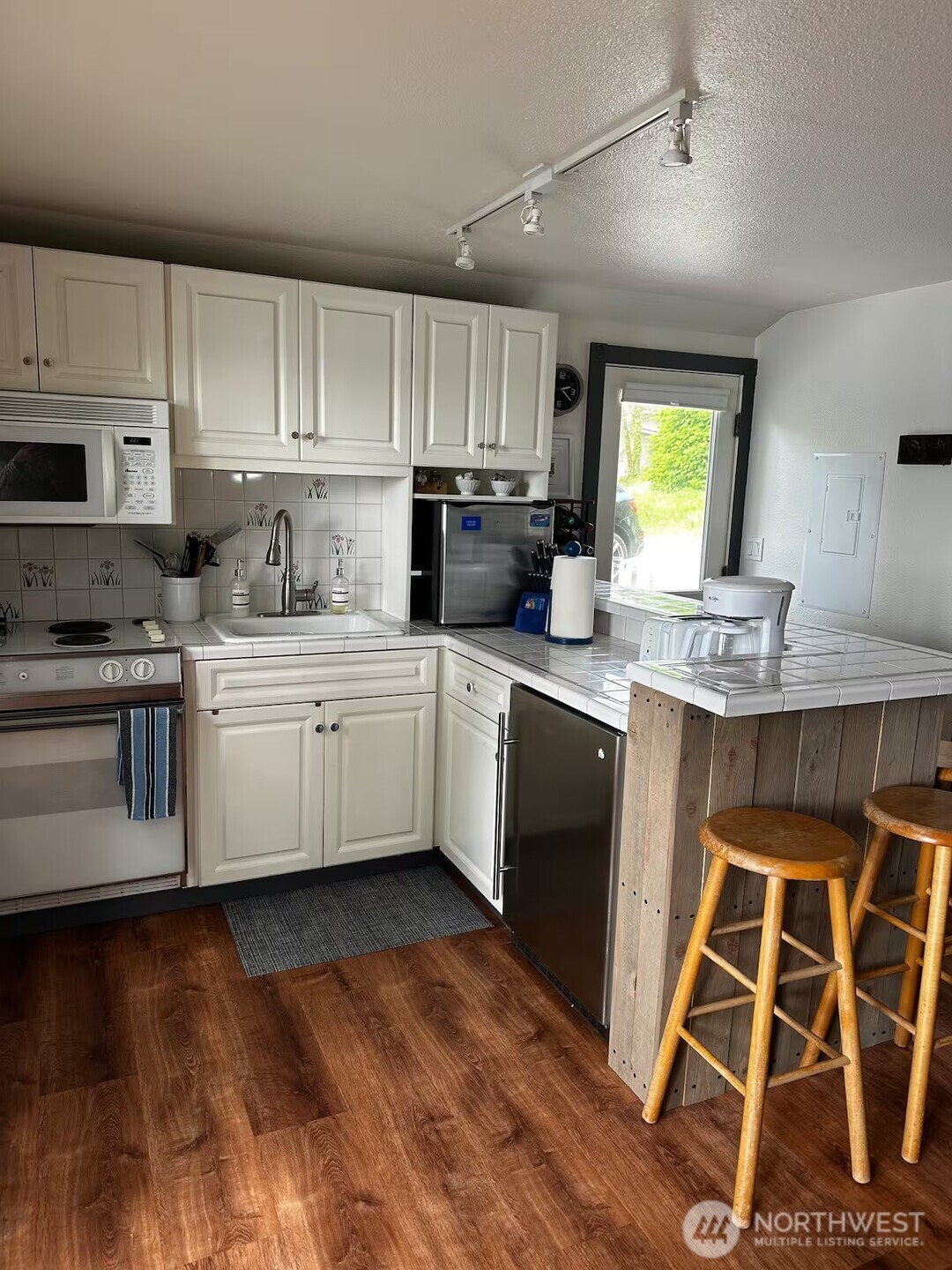 5244 Deer Harbor Road Orcas Island, WA 98243 - Photo 27 of 38 a kitchen with stainless steel appliances kitchen island granite countertop a sink dishwasher a stove a refrigerator and cabinets with wooden floor