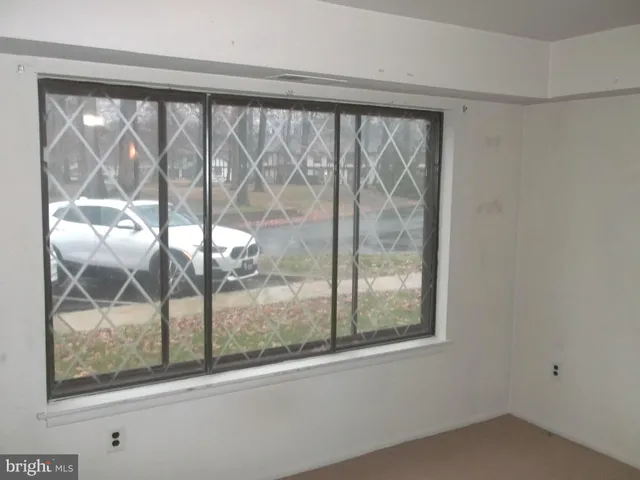 a view of a room that has a large window and front door