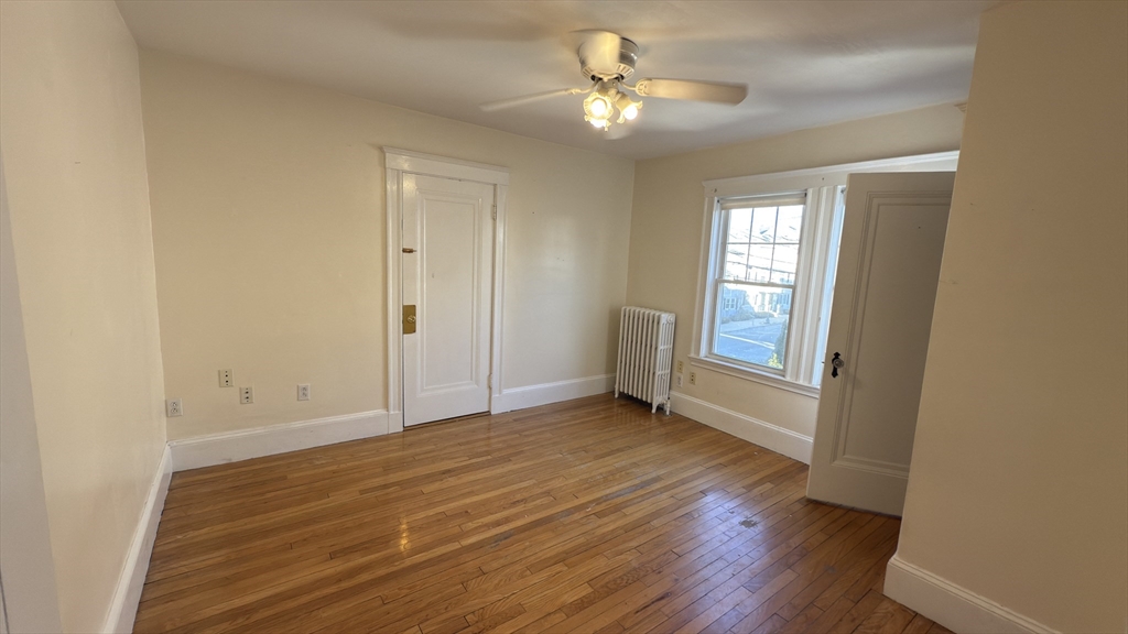 70 Union Street, Unit 2 Boston, MA 02135 - Photo 12 of 17 wooden floor in an empty room with a window