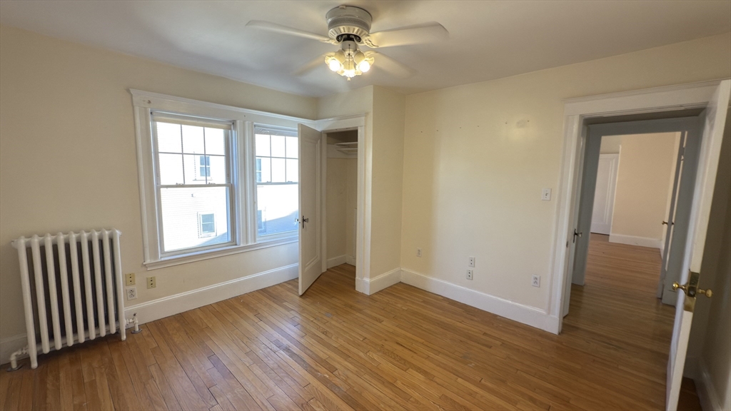 70 Union Street, Unit 2 Boston, MA 02135 - Photo 13 of 17 an empty room with wooden floor fan and windows