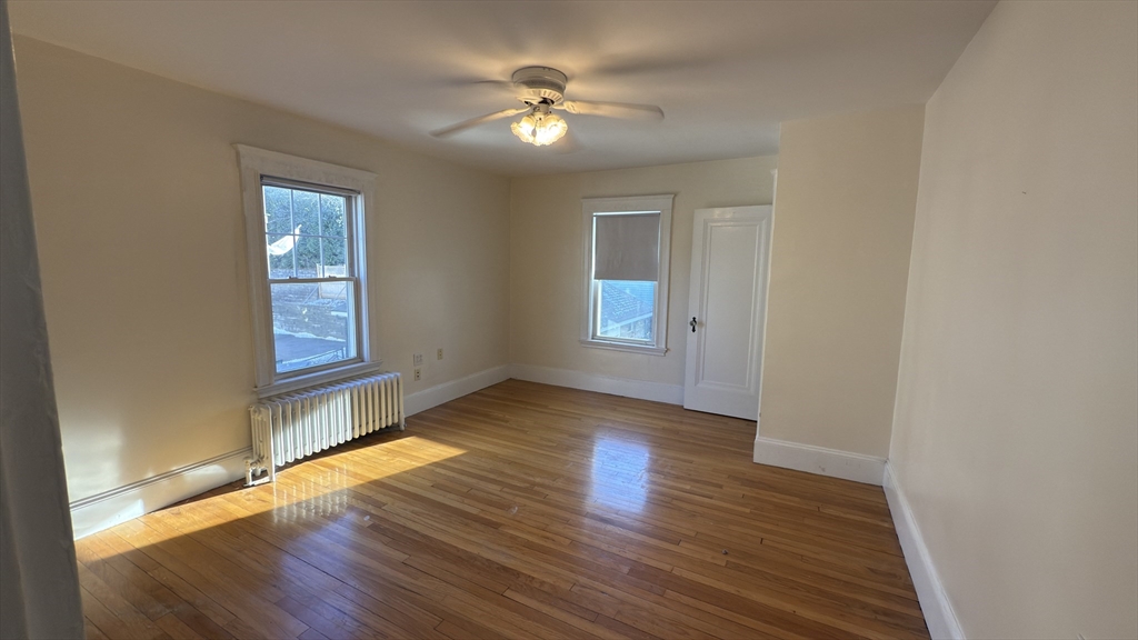 70 Union Street, Unit 2 Boston, MA 02135 - Photo 16 of 17 an empty room with wooden floor and windows