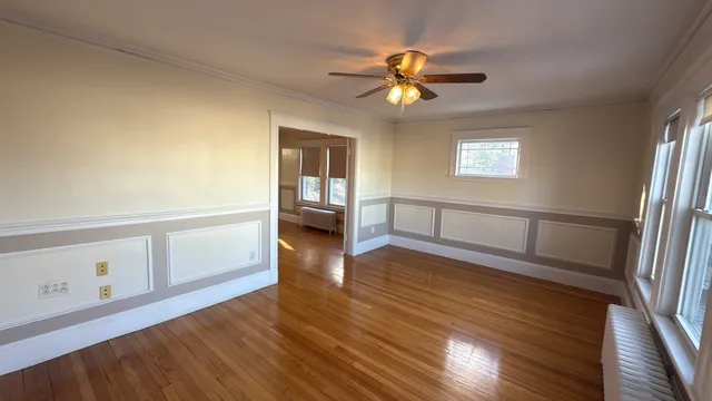 a view of a livingroom with wooden floor and a ceiling fan