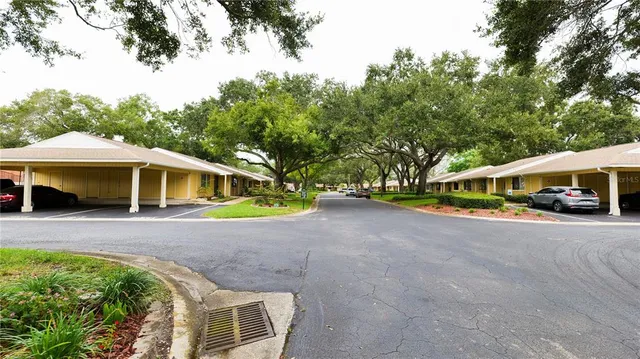 a front view of a house with a garden and trees
