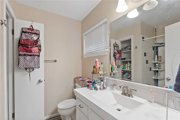 a bathroom with a sink vanity mirror and toilet