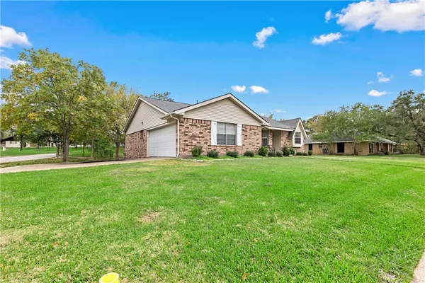 a front view of house with yard and green space