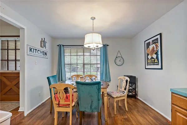 a dining room with furniture a chandelier and wooden floor