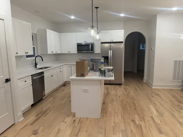 a kitchen with stainless steel appliances granite countertop a sink a stove and refrigerator