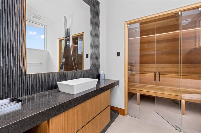 a spacious bedroom with a balcony a bed a fireplace and a large window