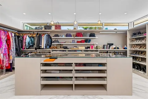 a kitchen with stainless steel appliances granite countertop a stove a refrigerator a sink a dining table and chairs with wooden floor