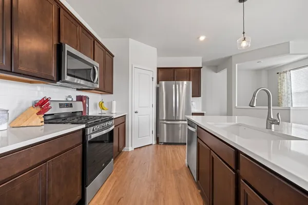 a kitchen with stainless steel appliances granite countertop a sink stove and refrigerator