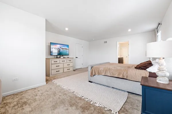 a bedroom with a bed and a view of living room