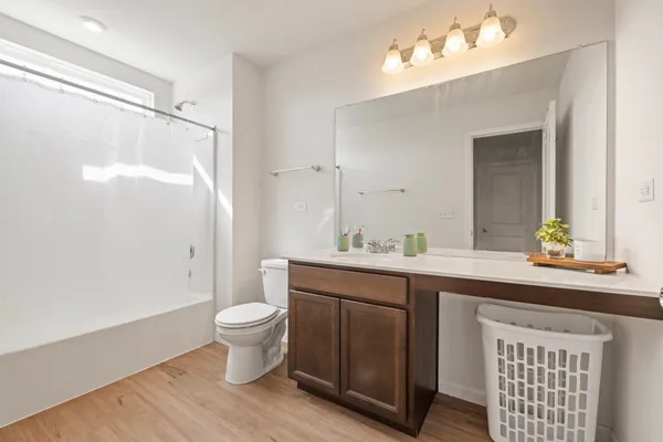 a spacious bathroom with a double vanity sink toilet and a mirror