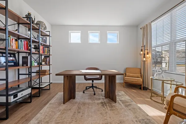 a view of a workspace with furniture and a window