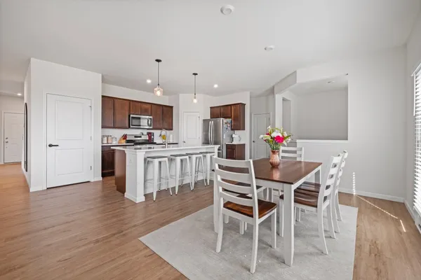 a kitchen with stainless steel appliances kitchen island granite countertop a dining table chairs and granite counter tops