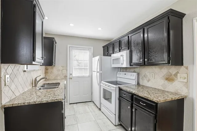 a kitchen with granite countertop stainless steel appliances and sink
