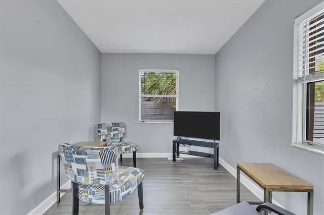 a living room with furniture a window and a flat screen tv