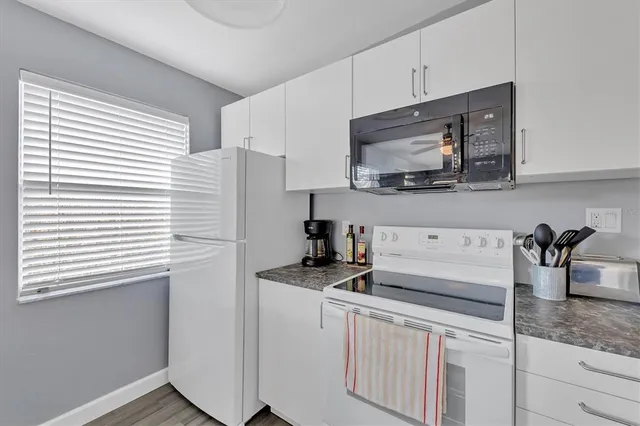 a kitchen with stainless steel appliances granite countertop a sink stove and microwave