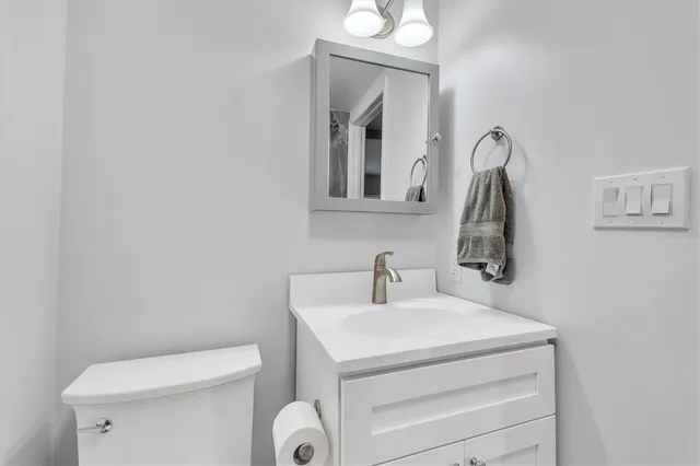 a bathroom with a toilet sink and mirror