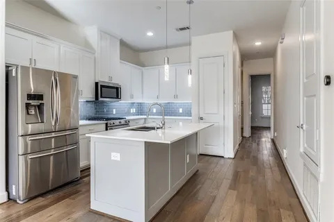 a kitchen with kitchen island white cabinets and stainless steel appliances