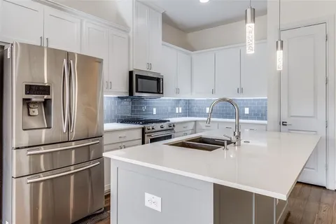 a kitchen with kitchen island a sink appliances and cabinets