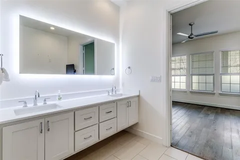a spacious bathroom with a double vanity sink a mirror and a
