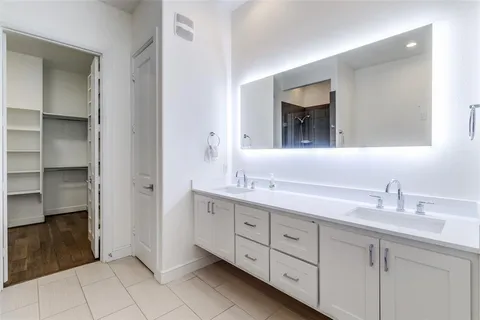 a bathroom with a double vanity sink and mirror