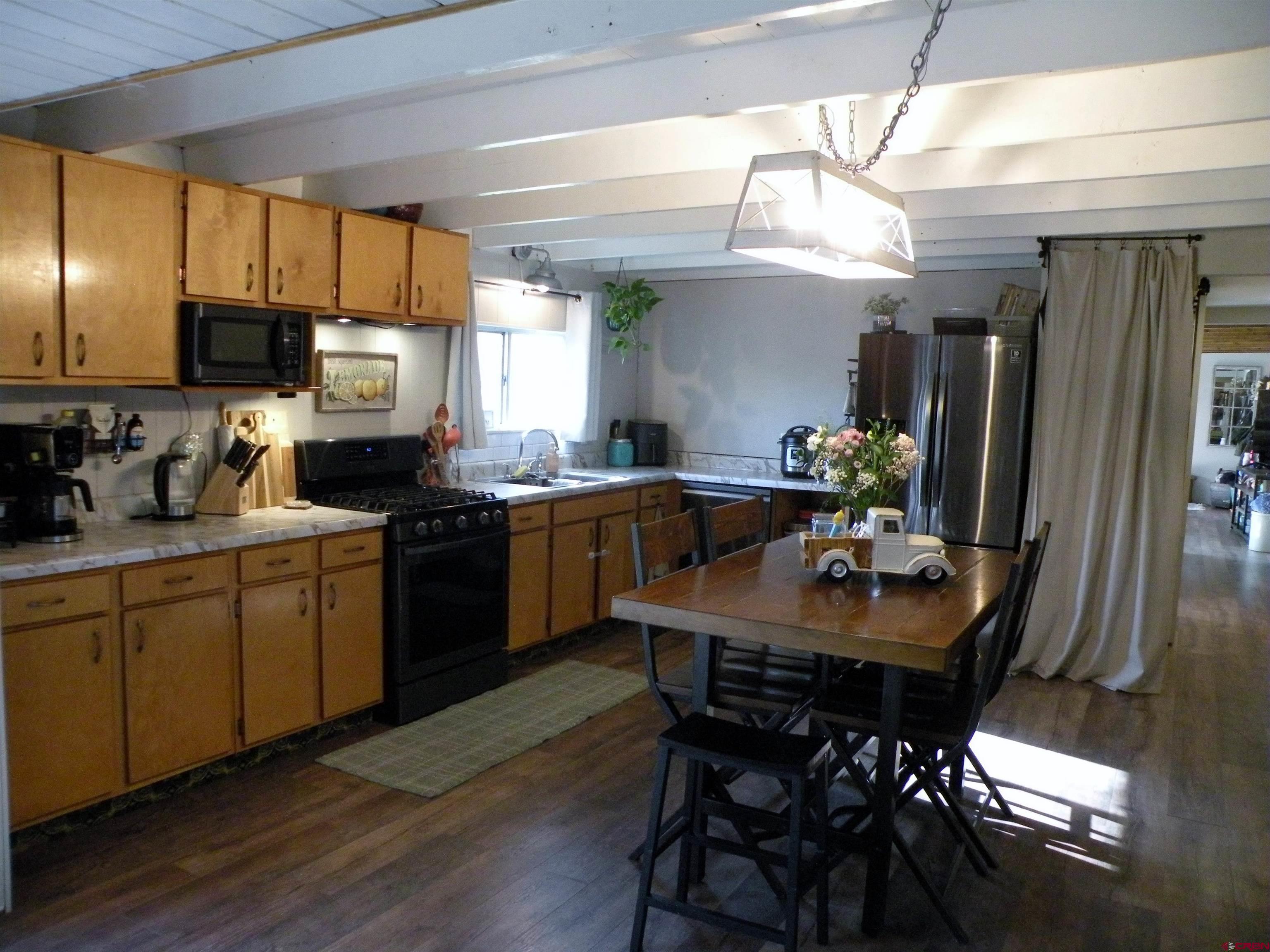 810 Grape Street Nucla, CO 81424 - Photo 18 of 31 a kitchen with a table chairs refrigerator and microwave