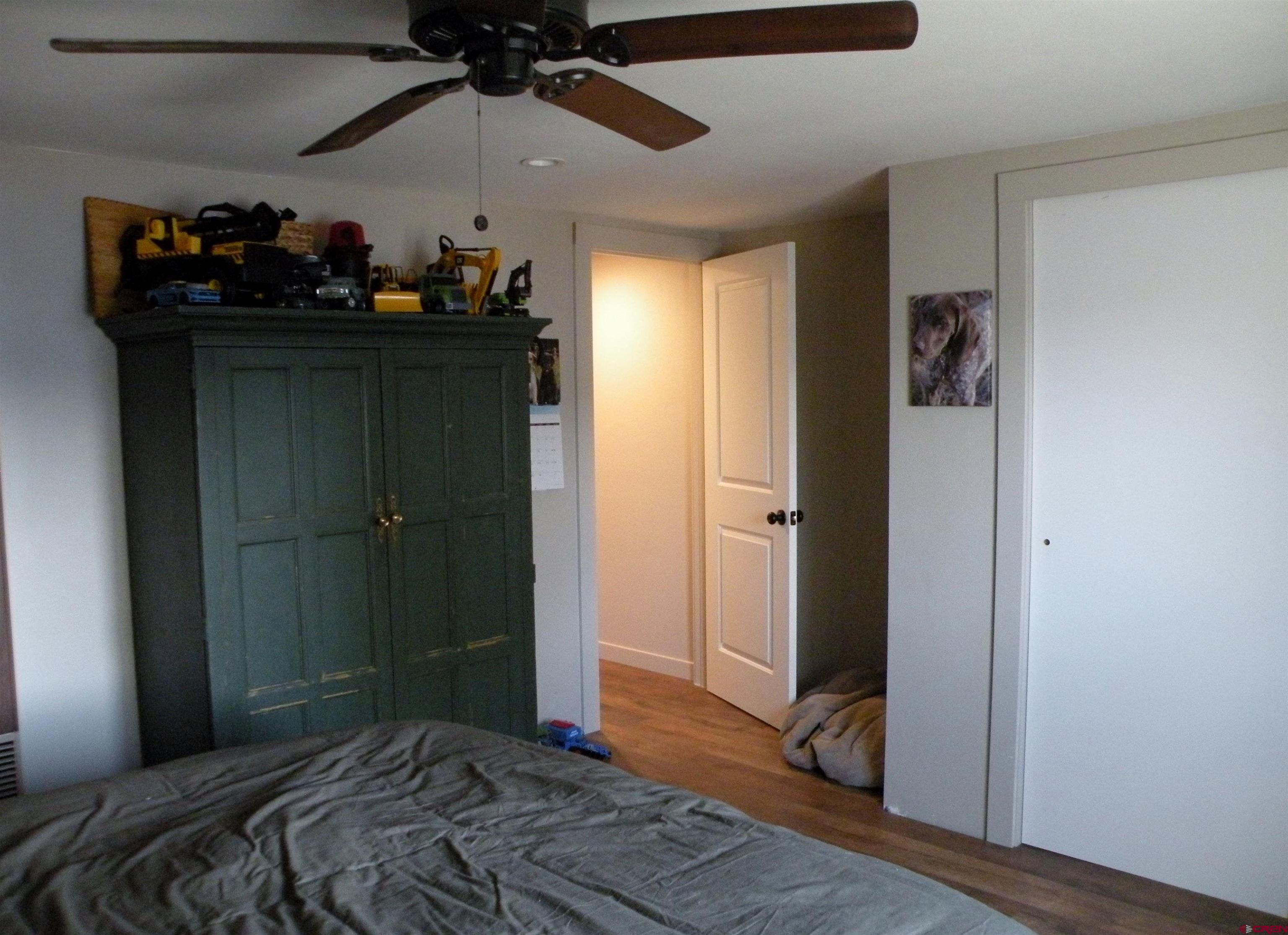 810 Grape Street Nucla, CO 81424 - Photo 30 of 31 a bedroom with a bed and wooden floor