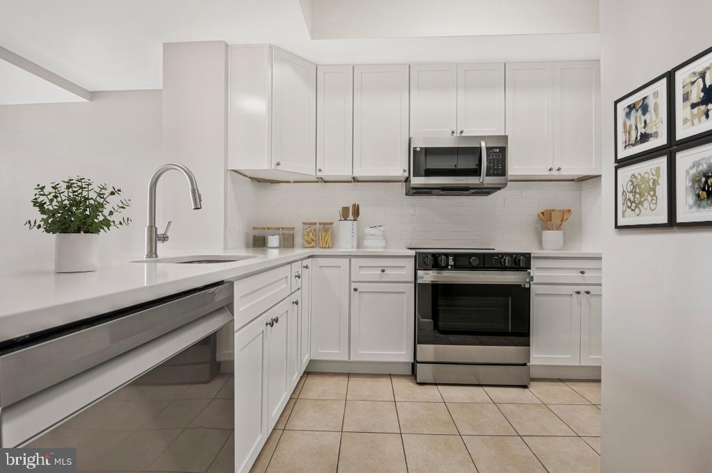 400 Massachusetts Avenue Northwest, Unit 1322 Washington, DC 20001 - Photo 14 of 37 a kitchen with stainless steel appliances granite countertop a sink and a stove