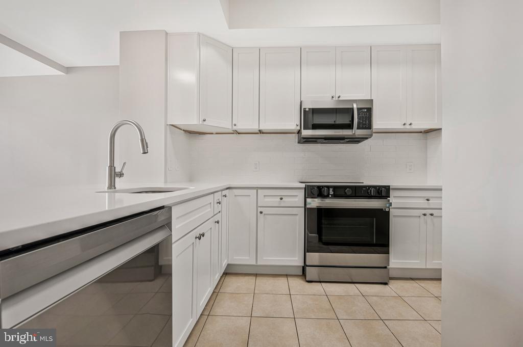400 Massachusetts Avenue Northwest, Unit 1322 Washington, DC 20001 - Photo 15 of 37 a kitchen with stainless steel appliances granite countertop a stove a sink and a microwave