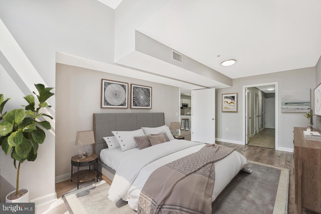 400 Massachusetts Avenue Northwest, Unit 1322 Washington, DC 20001 - Photo 19 of 37 a bedroom with a large bed and a potted plant