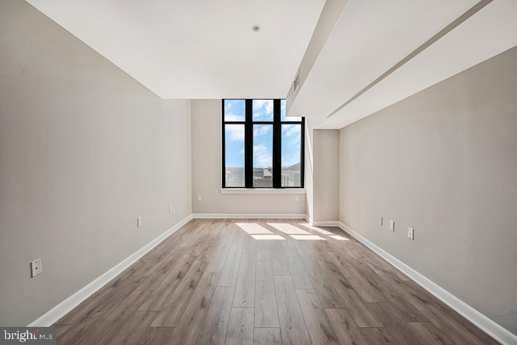 400 Massachusetts Avenue Northwest, Unit 1322 Washington, DC 20001 - Photo 22 of 37 wooden floor in an empty room with a window