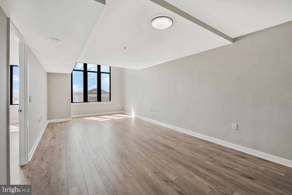 400 Massachusetts Avenue Northwest, Unit 1322 Washington, DC 20001 - Photo 8 of 37 wooden floor in an empty room with a window