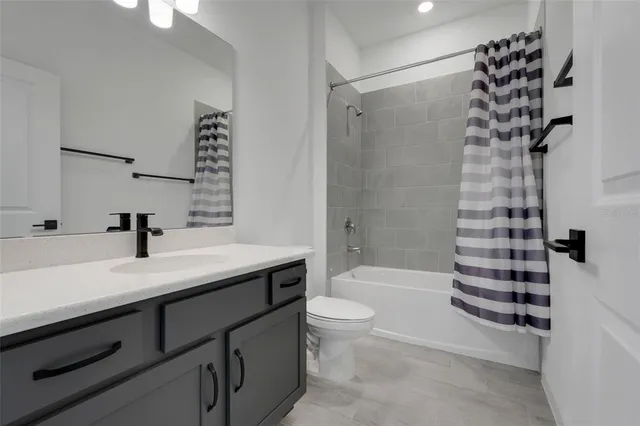 a bathroom with a sink a toilet a tub and shower