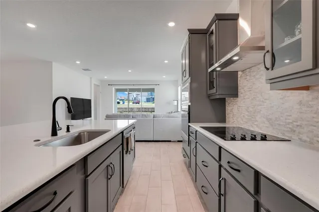a kitchen with stainless steel appliances granite countertop a sink a stove and a wooden floors