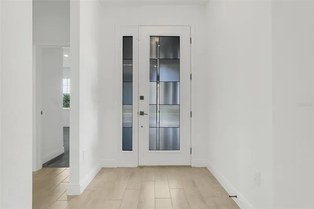 an empty room with wooden floor and entrance