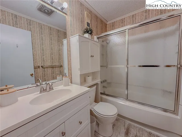 a bathroom with a sink toilet a mirror and shower